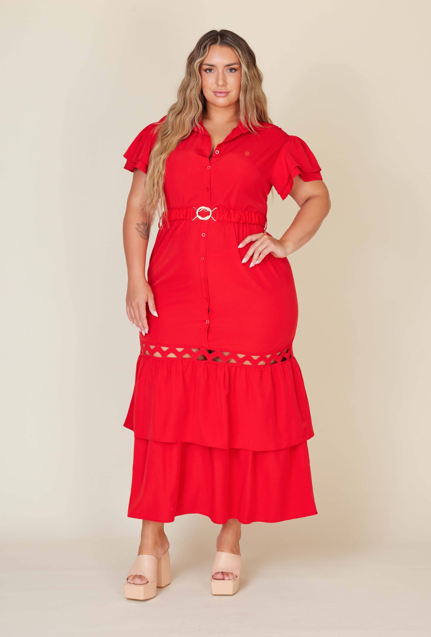 Woman wearing a red dress with a belt on a beige background